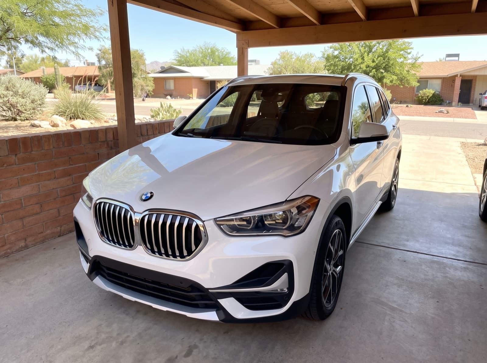 A white SUV under a carport in Tucson, AZ, after a Bang AutoGlass mobile glass job